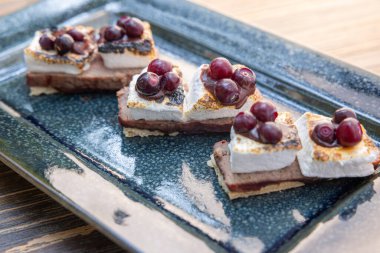 Lezzetli yaban mersini et dükkanları, kızarmış marşmelov, erimiş çikolata ve açık havada servis edilen yabanmersini sosu.