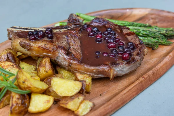 Grilled Bone Ribeye Served Potatoes Asparragus Topped Fresh Huckleberry Port — Stock Photo, Image