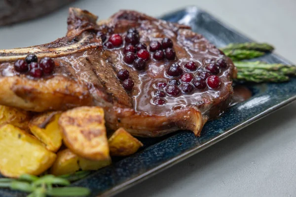 Grilled Bone Ribeye Served Potatoes Asparragus Topped Fresh Huckleberry Port — Stock Photo, Image
