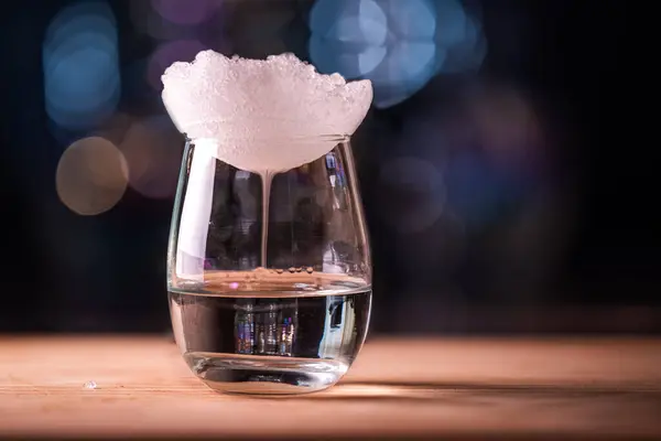 靠近一个清澈的玻璃杯 顶部有冰块和燃烧的酒精饮料 在不同的温度下产生浓雾 — 图库照片