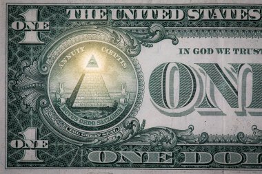 Bir dolarlık banknotun küçük bir bölümünü kapat. Her şeyi gören gözü ve piramidi ışıltılı göster..