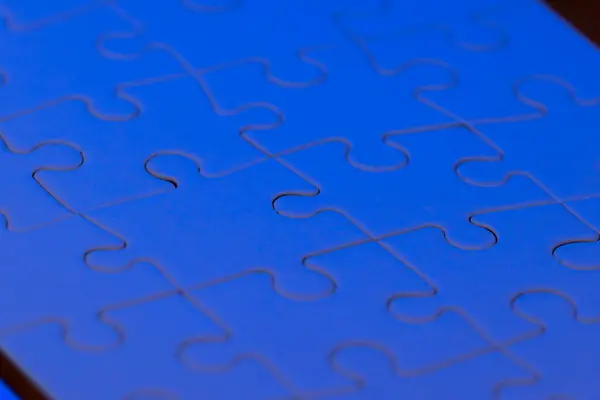 close up of a blank puzzle with a blue light as a concept