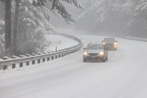 Passenger vehicles driving on snow covered highway 101 in Southern Oregon, February 2023