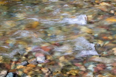 Doğal olarak Montana 'daki Buzul Ulusal Parkı' nda suyun altındaki renkli nehirler kayalar.