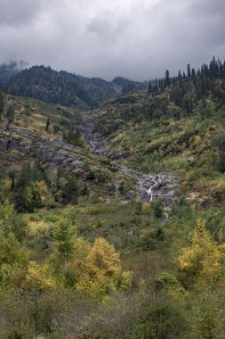 Buzul Ulusal Parkı 'nın güzel ve dramatik manzarası. Uzun, pürüzlü dağlar ve şelaleler kayalıklardan aşağı akıyor.