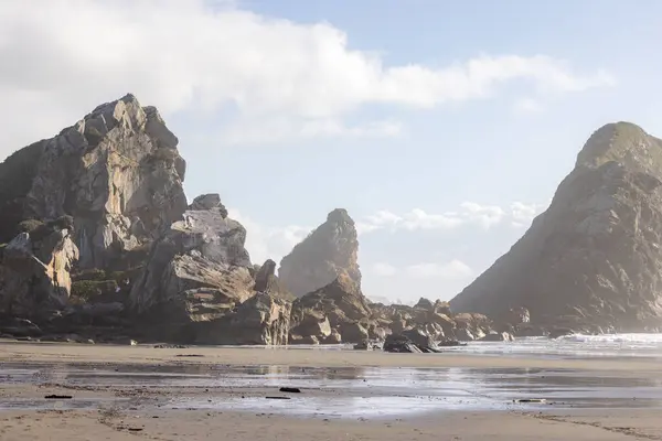 背景是一个多云的岩石海滩 海滩上空无一人 岩石四处散落 — 图库照片