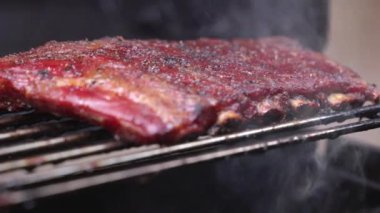 Izgarada bir pirzola rafı pişiyor. Kaburgaları kahverengi ve dumanlı bir tadı var.