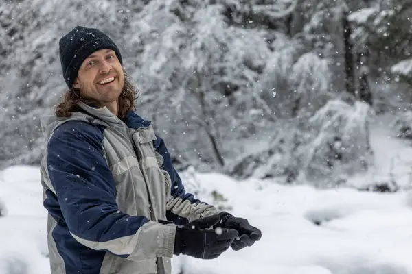 Чоловік Синьо Сірій Куртці Посміхається Снігу Він Тримає Пару Рукавичок — стокове фото