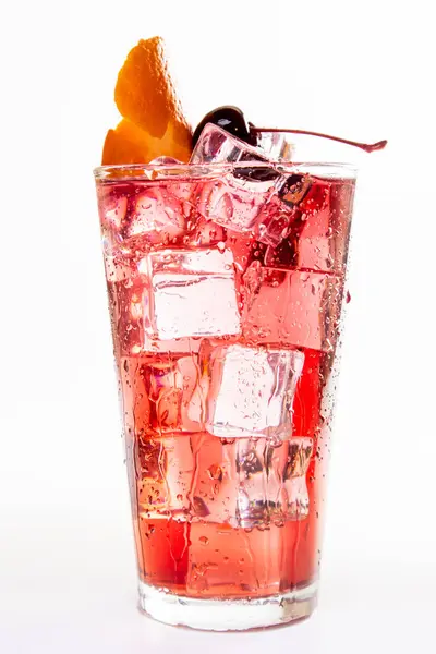 氷のキューブと上にチェリーが付いている赤い飲み物のグラス 飲み物は寒くて爽やかで 暑い日にはぴったりです — ストック写真