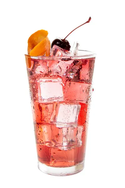 上にチェリーが付いている赤い飲み物のグラス その飲み物は冷たくて爽やかです チェリーは色のポップと飲み物への甘さのタッチを追加します ガラスは氷で満たされています ロイヤリティフリーのストック写真
