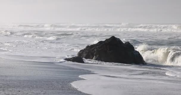 Пляже Рядом Океаном Расположена Большая Скала Скала Окружена Белой Пеной Лицензионные Стоковые Видео