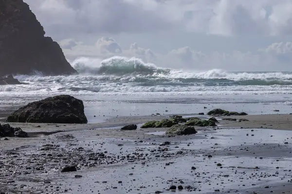 Büyük Bir Dalganın Kıyıya Vurduğu Kayalık Bir Sahil Dalgalı Gökyüzü — Stok fotoğraf