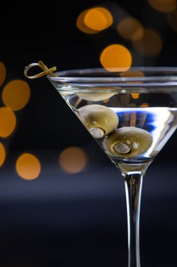 İçinde zeytin olan bir martini bardağı. Zeytinler içkinin içinde marine ediliyor ve bardaklar dolu.