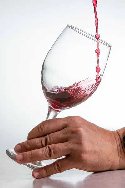 Action Shot Gießt Rotwein Ein Glas Vor Weißem Hintergrund — Stockfoto