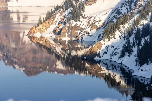 一座美丽的雪山 背景上有一个湖 湖面反射着群山和天空 图库图片