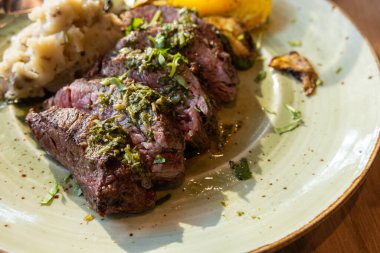 Patates püresi ve sebzeli bir tabak et. Et mükemmel pişirilir ve baharatlanır, ve sebzeler kızarır..