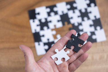 Sırt ve beyaz bulmaca ve kayıp deliğe uyan beyaz ve siyah yapboz parçası kullanan kavramsal görüntü.