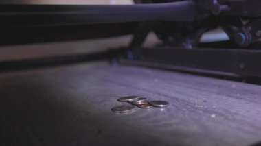 Kanepenin altını aramak için el feneri kullanan ve bozuk paraları keşfeden biri için gerçekçi bir an. Görünür toz ve yıpranmış koltuk yayları bu günlük sahnenin gerçekliğini artırıyor..