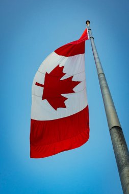 Canada flag hanging limply from tall flagpole clipart