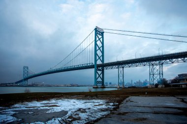 Windsor Ontario Ambassador Bridge to Detroit Michigan on a cloudy winter day clipart
