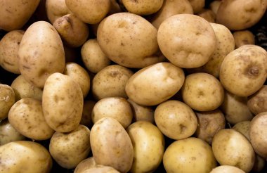 Süpermarkette sebze standında satılan taze patates yığını organik yiyecekler, vejetaryen yiyecekler ve sağlıklı yiyecekler gösteriyor. Doku ve arka plan için pazar kullanımında patates satışı yığını.