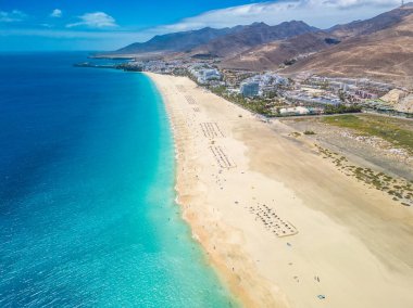 White sandy beach and blue water in Morro Jable, south of Fuerteventura, Canary islands, Spain clipart