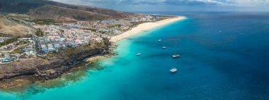 White sandy beach and blue water in Morro Jable, south of Fuerteventura, Canary islands, Spain clipart