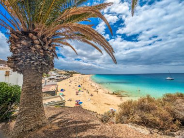 White sandy beach and blue water in Morro Jable, south of Fuerteventura, Canary islands, Spain clipart