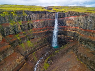 Aerial drone view of Hengifoss waterfall landscape in Iceland. Red layers of clay between basaltic layers. clipart