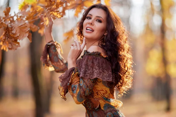 一个美丽的女子在一个阳光灿烂的秋日在森林里的画像 — 图库照片