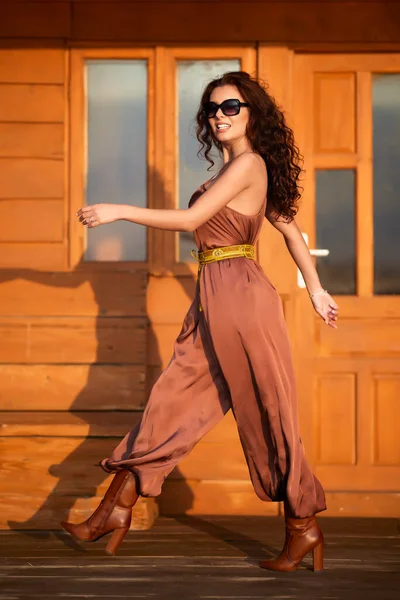 一个长头发的漂亮女人在木屋旁边摆出时尚的姿势 — 图库照片