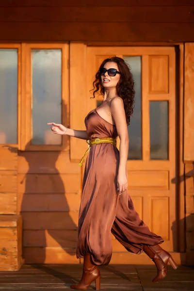 一个长头发的漂亮女人在木屋旁边摆出时尚的姿势 — 图库照片