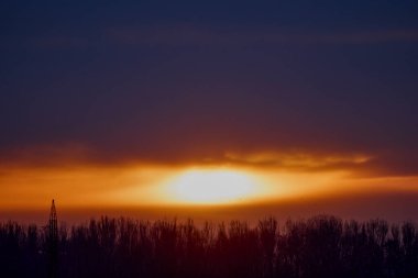 landscape with sky at sunset over a forest