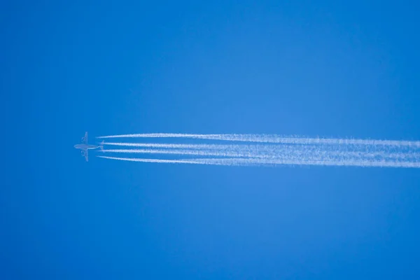 Airplane In Blue Sky With Plane Trails