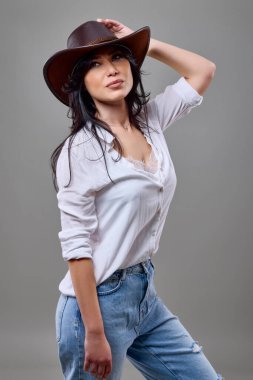 Güzel esmer bir kadının portresi. Stüdyoda şapkalı sıradan bir kadın.