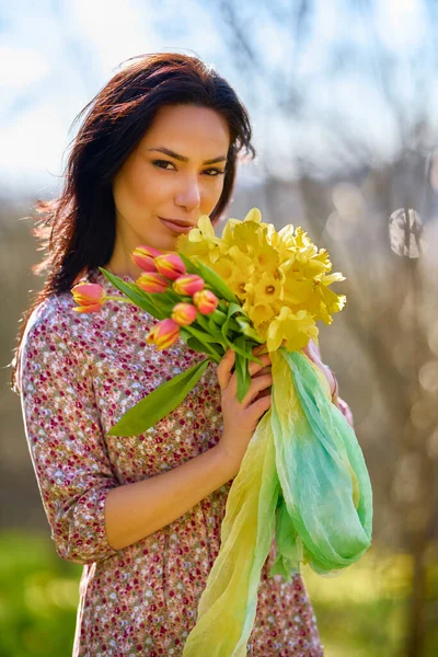 春天的一天 一个美丽的女人在一个有黄色雪花的花园里的画像 — 图库照片