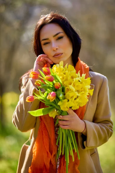 春天的一天 一个美丽的女人在一个有黄色雪花的花园里的画像 — 图库照片