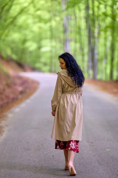 在树林中的路上的一个黑发女人的画像 — 图库照片