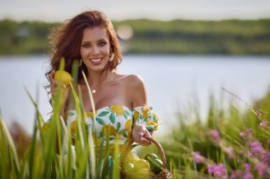 Limonlu güzel bir kadının portresi gölün yakınındaki bir çayırda..