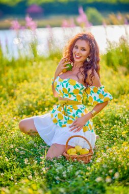 Limonlu güzel bir kadının portresi gölün yakınındaki bir çayırda..