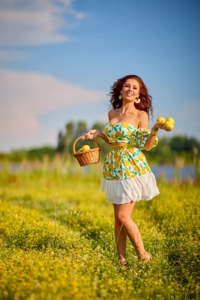 一个美丽的女人的肖像 她在湖边的草地上拿着柠檬 — 图库照片
