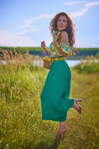一个美丽的女人的肖像 她在湖边的草地上拿着柠檬 — 图库照片