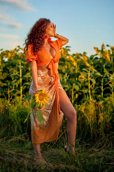 夕暮れ時の晴れた日のひまわり畑の近くに美しい女性の肖像画 — ストック写真