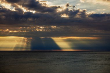 Sabahları denizin üstünde yağmur bulutları olan manzara..