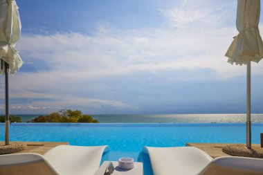 Deniz kenarında sonsuz havuzu olan güzel bir manzara..