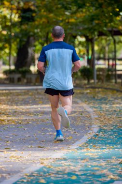 Bir sonbahar günü parkta koşan orta yaşlı bir adamın portresi..
