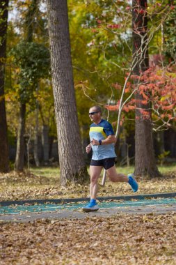Bir sonbahar günü parkta koşan orta yaşlı bir adamın portresi..
