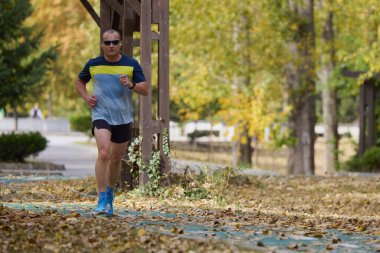 Bir sonbahar günü parkta koşan orta yaşlı bir adamın portresi..