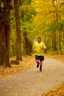Bir sonbahar günü parkta koşan orta yaşlı bir adamın portresi..