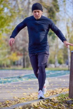 Bir sonbahar günü parkta koşan orta yaşlı bir adamın portresi..